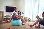 Playful father and kids exercising in living room