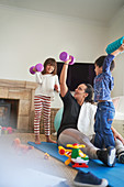 Mother and kids exercising with dumbbells