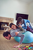 Playful kids on top of father exercising