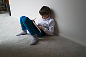 Boy home schooling on floor