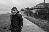 Portrait muddy boy on rural footpath