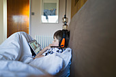Boy e-learning with digital tablet in bed