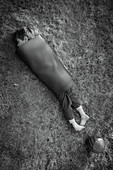 Boy wrapped in yoga mat in grass