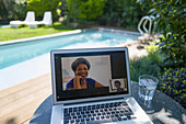 Women video conferencing at poolside