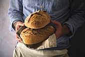 Man holding fresh home baked sourdough bread