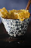 Close up dripping honeycomb in bowl