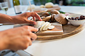 Woman slicing cheese on cutting board