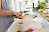 Woman cutting herbs for chicken dish