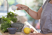 Woman cooking with olive oil and mortar
