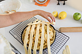 Woman arranging lattice over apple pie