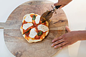 Woman slicing fresh homemade pizza