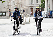 Couple riding bicycles on city street