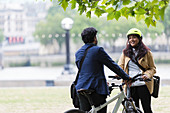 Business people with bicycles talking in city park