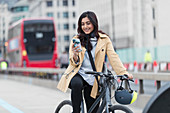 Businesswoman on bicycle, London, UK