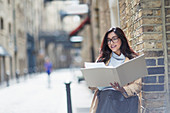 Businesswoman reviewing paperwork on city street