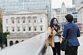 Business people in face masks talking, London, UK