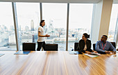 Businessman talking at highrise window, London, UK