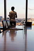 Businesswoman standing at highrise office window