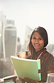 Businesswoman with paperwork at office window