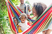 Toddler girl in summer hammock with family