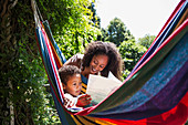 Mother and son reading book in hammock
