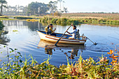 Young couple in rowboat on sunny river