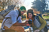 Young hiking couple using digital camera