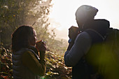 Silhouette couple drinking coffee in autumn nature