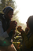 Happy hiker couple drinking coffee in sunny woods