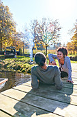 Happy couple relaxing on autumn dock near campsite