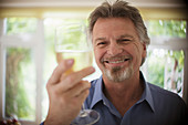 Close up Carefree senior man drinking white wine
