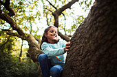 Happy girl climbing tree