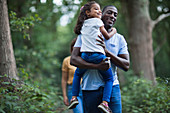 Happy father carrying daughter on hike in woods