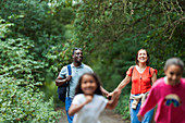 Happy family hiking on trail in woods