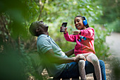 Happy father and daughter laughing on park bench