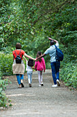 Family holding hands walking on path in park