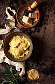 Ravioli in a bowl with parmesan cheese and breadcrumbs