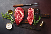 Raw black angus prime beef steaks on wooden cutting board