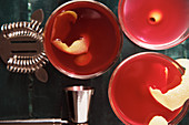 Rote Cocktails mit Zitronenschale und Oliven auf Bartheke