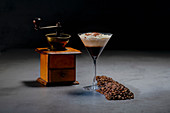 Roasted coffee beans and cocktail glass with yummy cappuccino with cream
