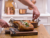 Grilled crispy roast pork being carved