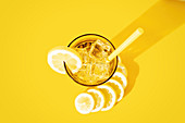 Glass of fresh beverage with lemons placed on table