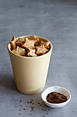 Appetizing homemade star shaped salted cookies with cumin seeds served in ceramic cup on marble table
