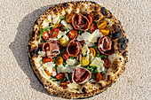 Gegrillte Cornicione-Pizza mit Tomaten, Prosciutto und Käse
