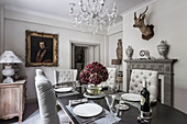 Deer's head above fireplace in dining room with glass chandelier