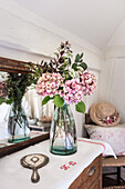 Pink hydrangeas with vintage hand mirror and vase from Garden Trading reflected in antique mirror