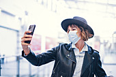 Woman in face mask taking selfie