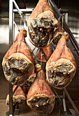 Cured ham hanging in an ageing chamber