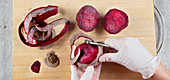 Disposable gloves being used to peel beetroot