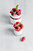 Glass filled with delicious pudding made with yogurt raspberries jam and chia seeds